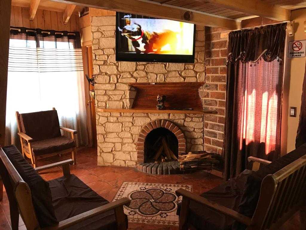 Stone fireplace and common seating area at Hotel y Cabañas Alan